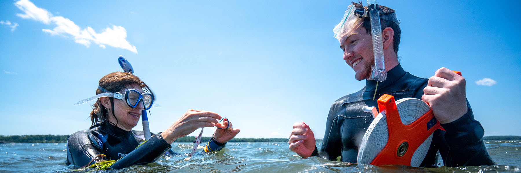 two researchers wearing wetsuits and snorkel gear