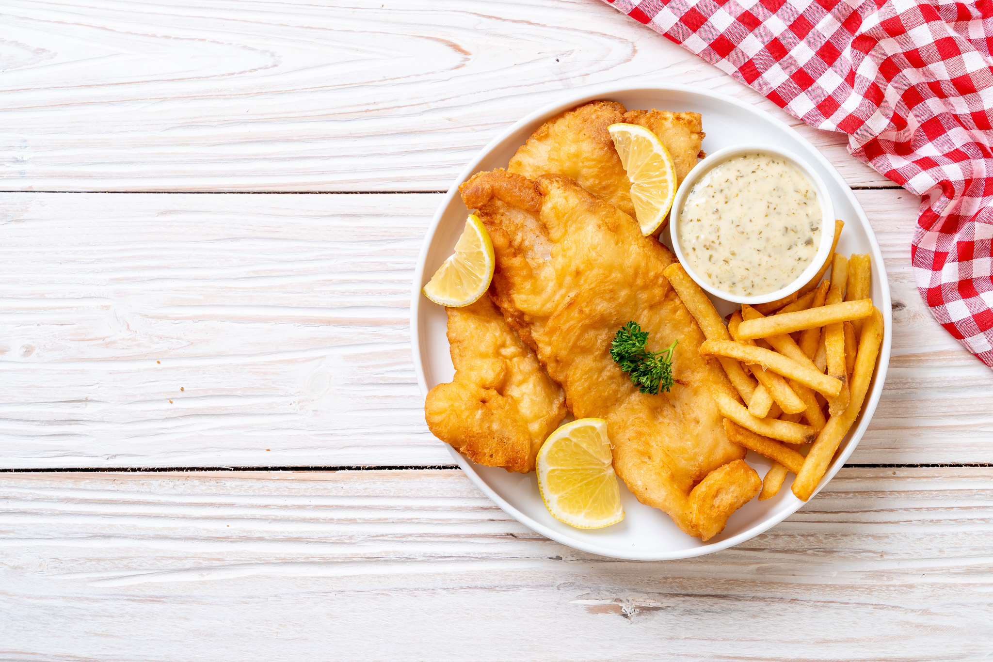 Fish and chips on a white table. 