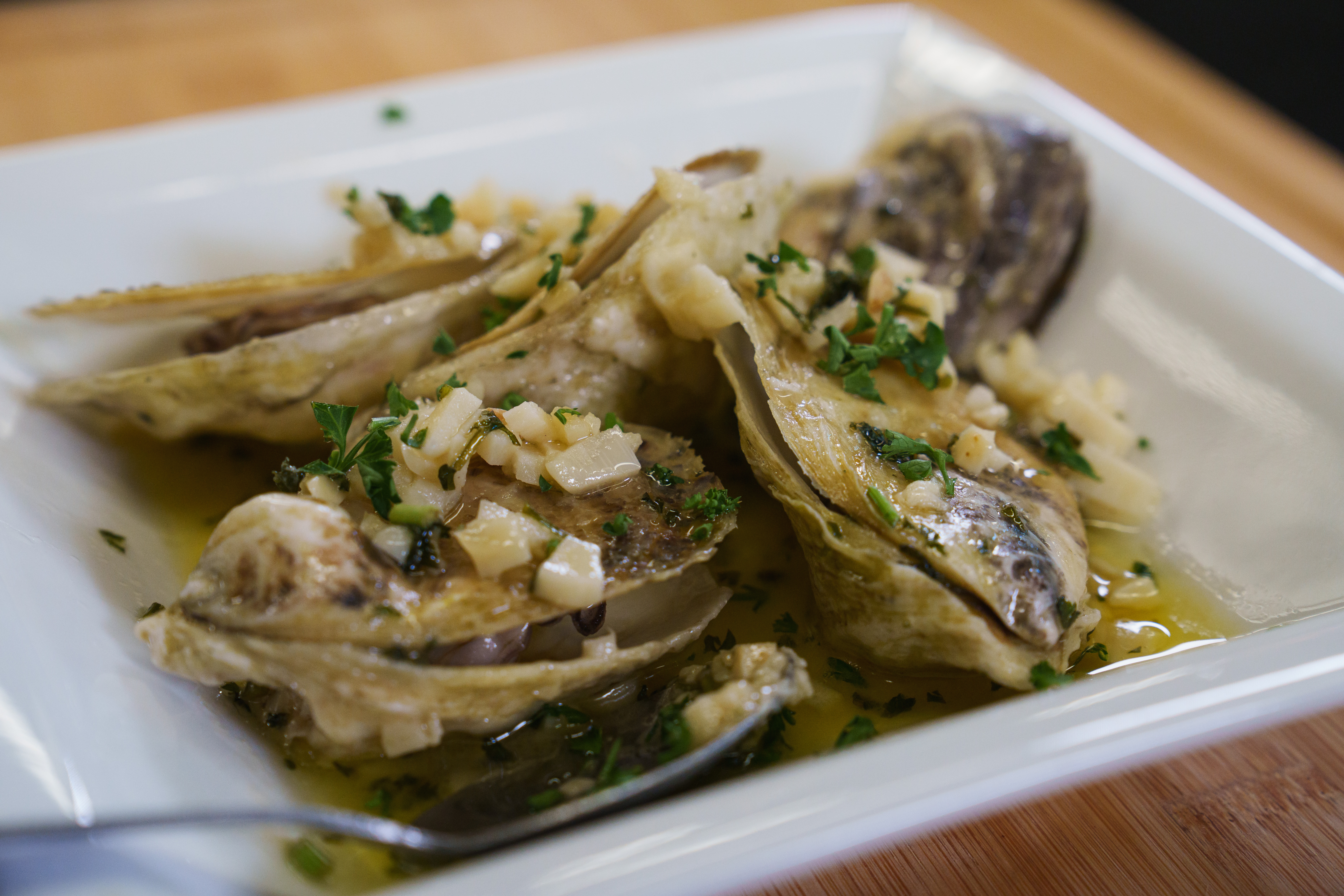 Sautéed oysters on a white plate, ready to serve.
