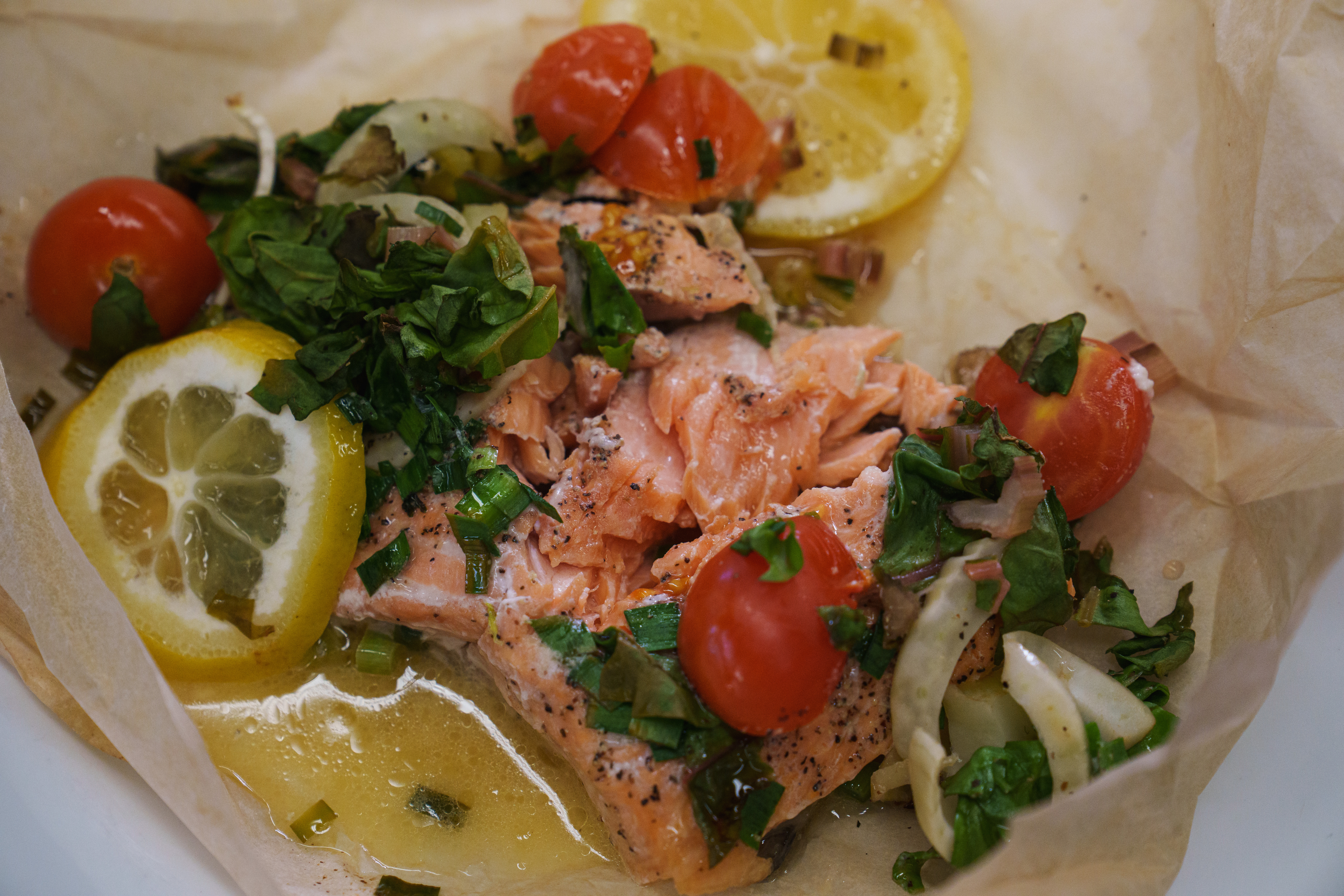 Trout en papillote, served on a plate with open parchment paper.
