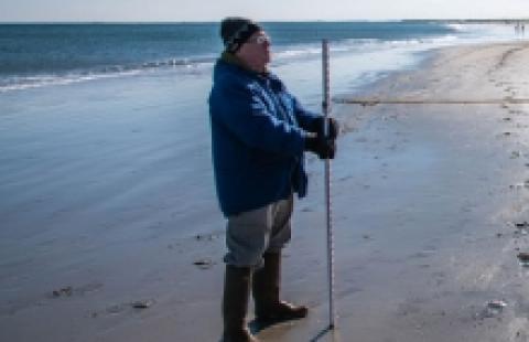 Man taking measurements on beach