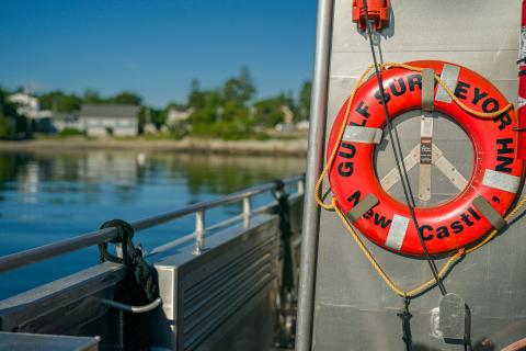 orange lifesaving ring mounted to the side of a steel-hulled research vessel