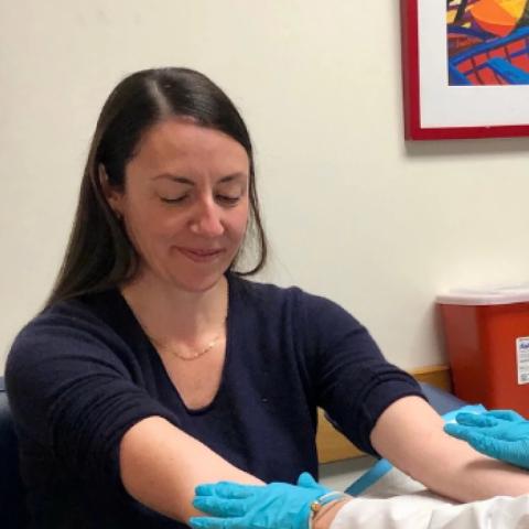 a woman in a doctors office holds out her arms as she is being examined by a doctor in gloves