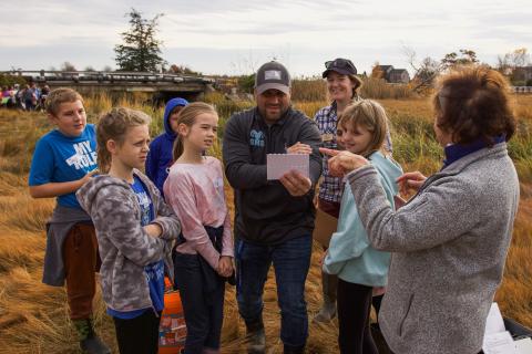 Students examine the pH of their local water body with their teacher.