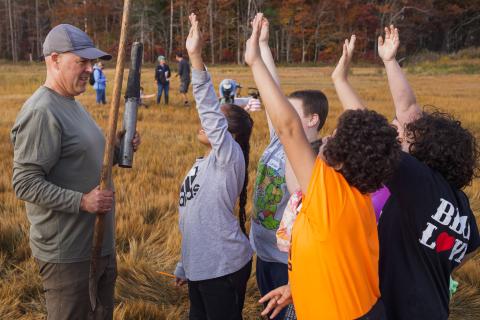 Students eagerly line up to collect core samples from the salt marsh. 