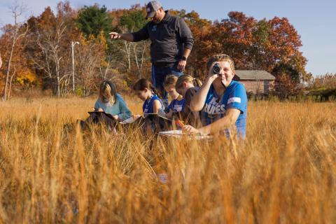 Students use mono-scopes to scan the salt marsh for birds, and other local species.