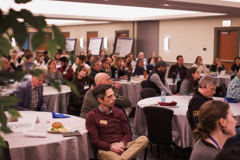 Attendees at the New Hampshire Sea Grant Research Symposium watch on as researchers showcase their projects. 