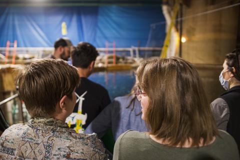 Two participants have a conversation about the barramundi aquaculture they are witnessing. 