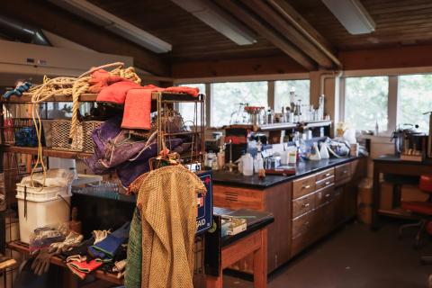 A lab table with equipment scattered about, including more nets and buckets in the foreground. 