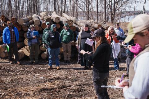The group assesses a wooded landscape along Great Bay.
