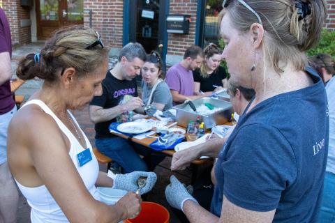 Laura Brown and Gabriela Bradt shuck oysters together.