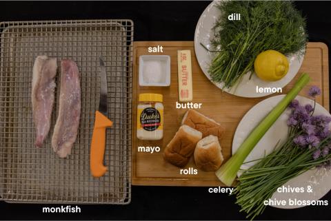 A layout of all the monkfish ingredients on a cutting board and table. 